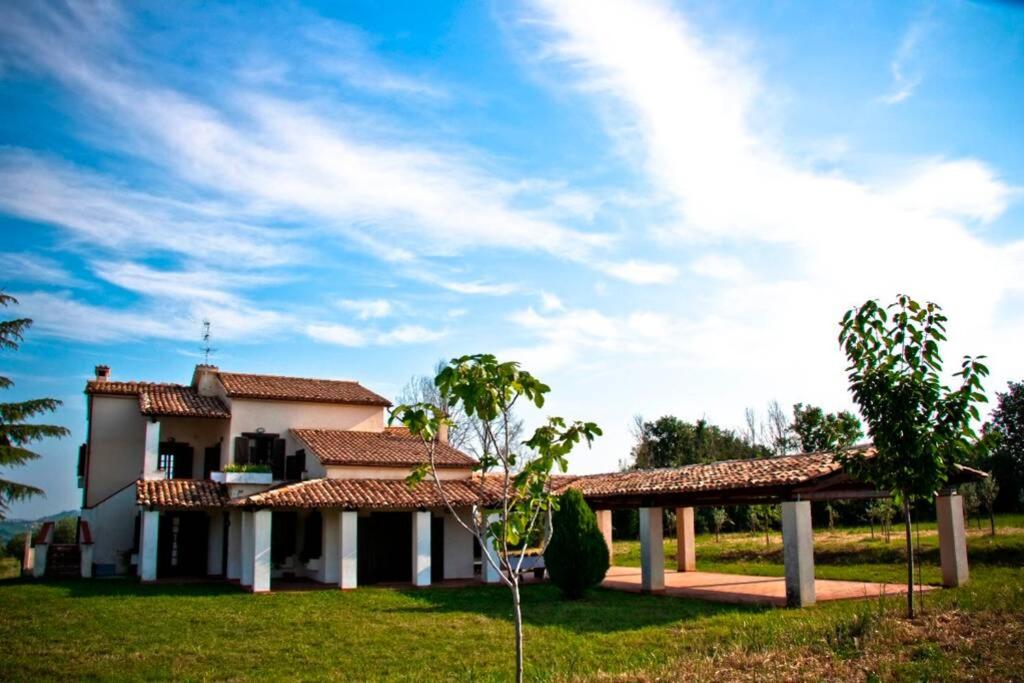 una casa con césped verde y cielo azul en La Prediletta Country House, en Rapino