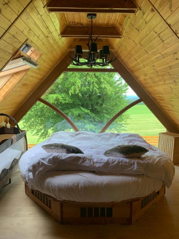 Bett in einem Zimmer mit einem großen Fenster in der Unterkunft Ferienhaus Jeschkenpanorama in Luftkurort Lückendorf