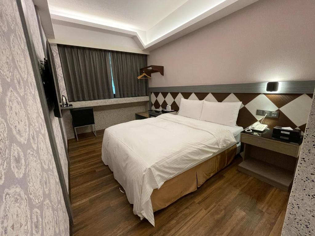 Una cama o camas en una habitación de Weifeng Boutique Business Hotel - Zhanqian Branch