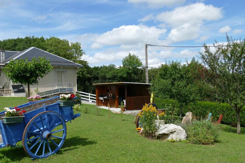 un jardin avec un wagon bleu dans la cour dans l'établissement Le Gîte de L'Adrech, à Lacaune