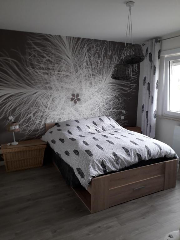 - une chambre avec un lit et un mur orné d'une fresque florale dans l'établissement La chambre Plume, à Truchtersheim