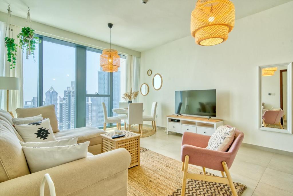 uma sala de estar com um sofá e uma televisão em Boho-Chic Cosy 1BR, minutes to Burj Khalifa em Dubai