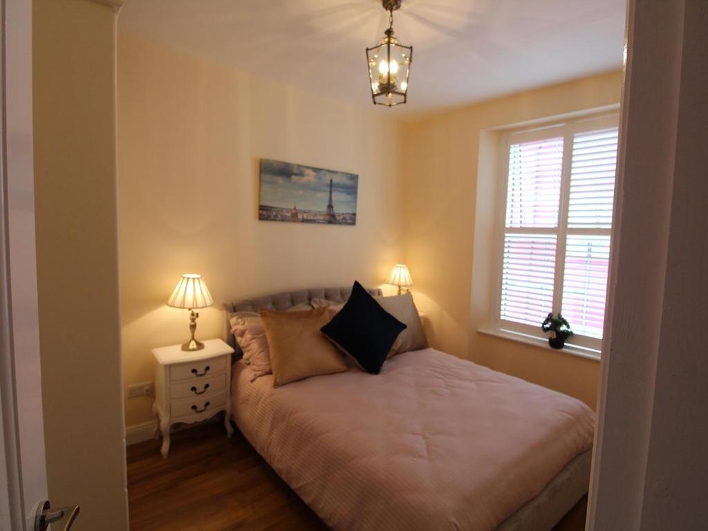 a small bedroom with a bed and a window at Garda House in Kinsale
