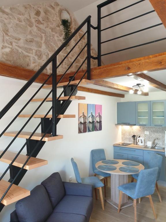 a kitchen and a living room with a spiral staircase at Apartments Lucky in Lozovac