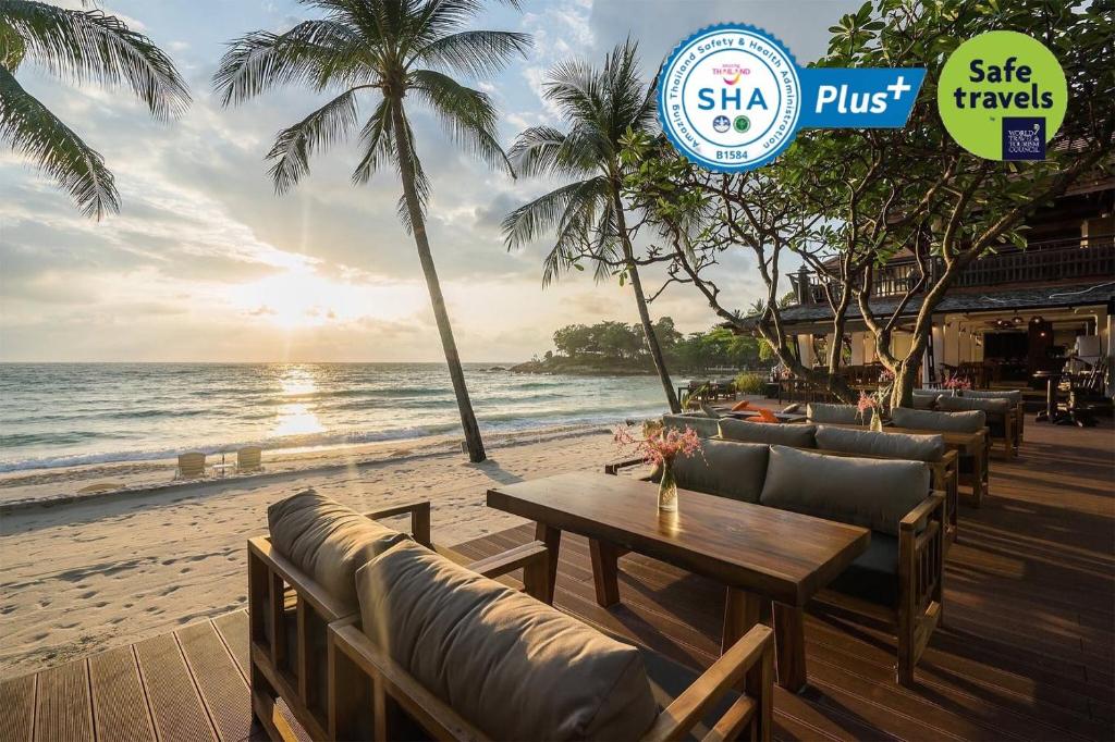 a table and chairs on a beach with the ocean at Samui Paradise Chaweng Beach Resort , SHA Plus in Chaweng