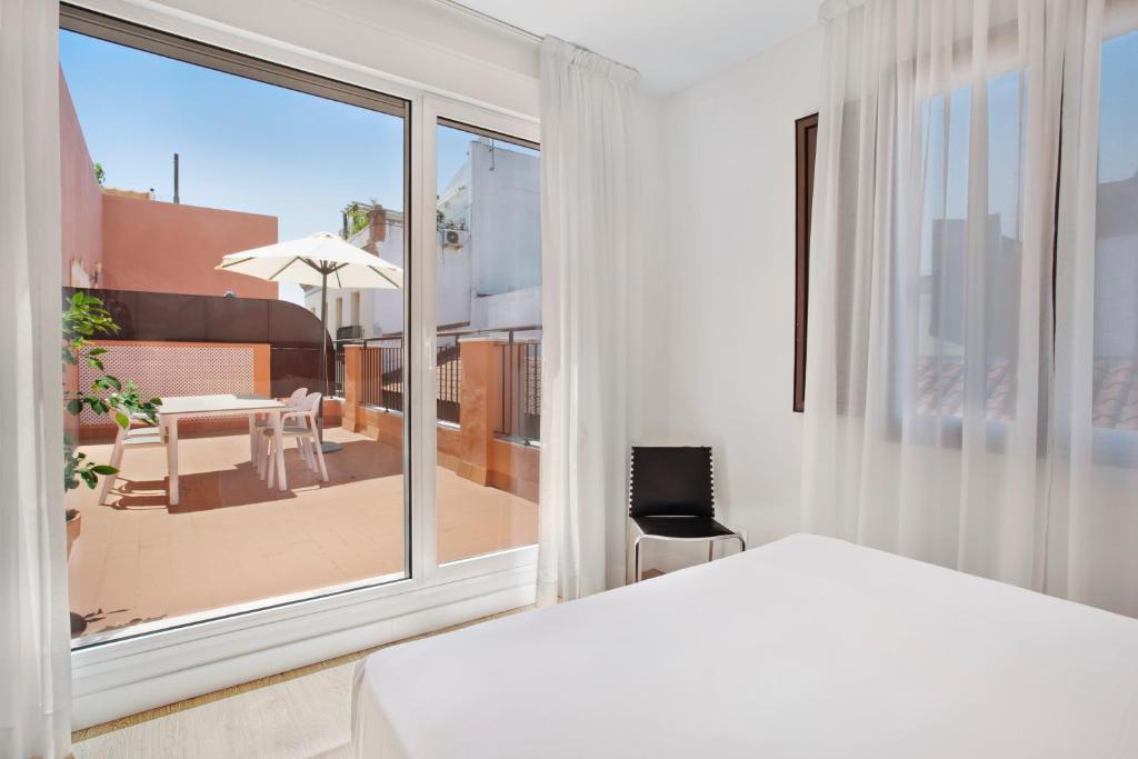 a bedroom with a bed and a view of a patio at Apartamentos Metrópolis in Seville