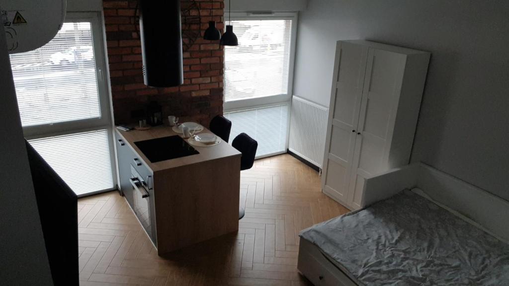 uma cozinha com uma secretária e uma cama num quarto em Apartament Zamkowy em Lublin