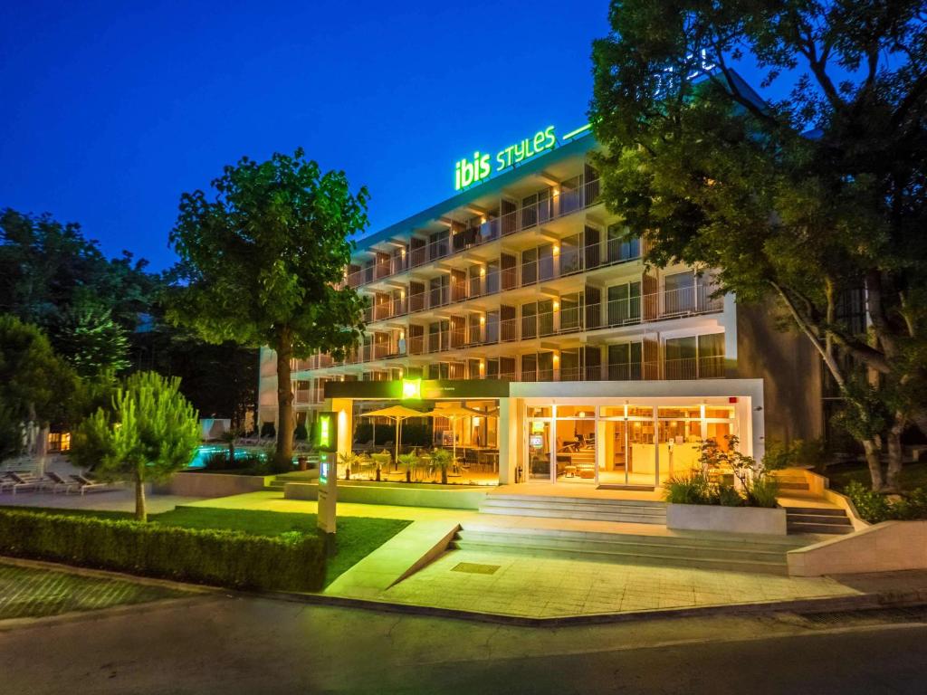 un hotel con un edificio illuminato di notte di ibis Styles Golden Sands Roomer Hotel a Golden Sands