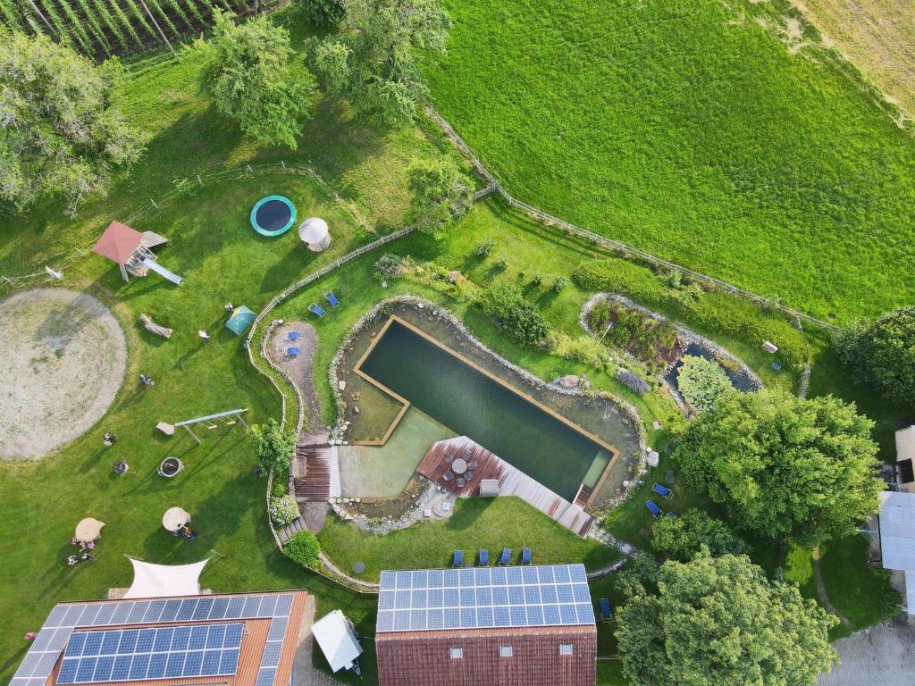 una vista aérea de un jardín con un estanque y paneles solares en Ferienhof Metzler, en Bodnegg