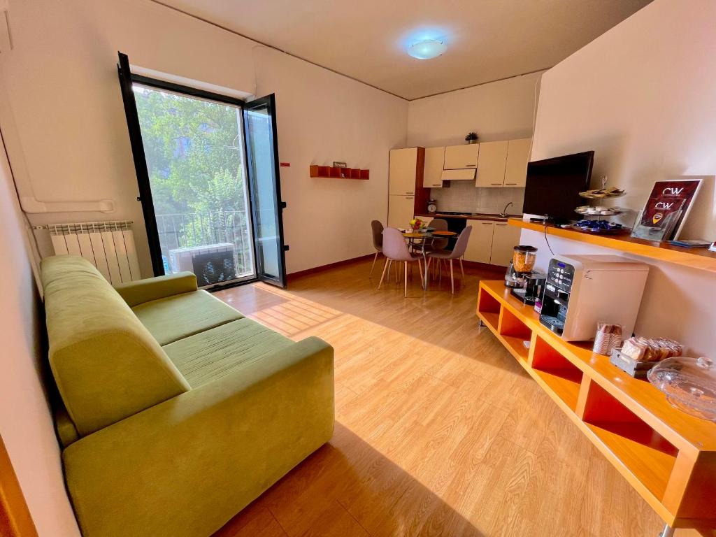 Il comprend un salon avec un canapé vert et une cuisine. dans l'établissement Maria Carolina Casavacanze, à Caserte