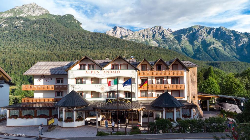 a hotel in the mountains with mountains in the background at Hotel Alpen in Andalo