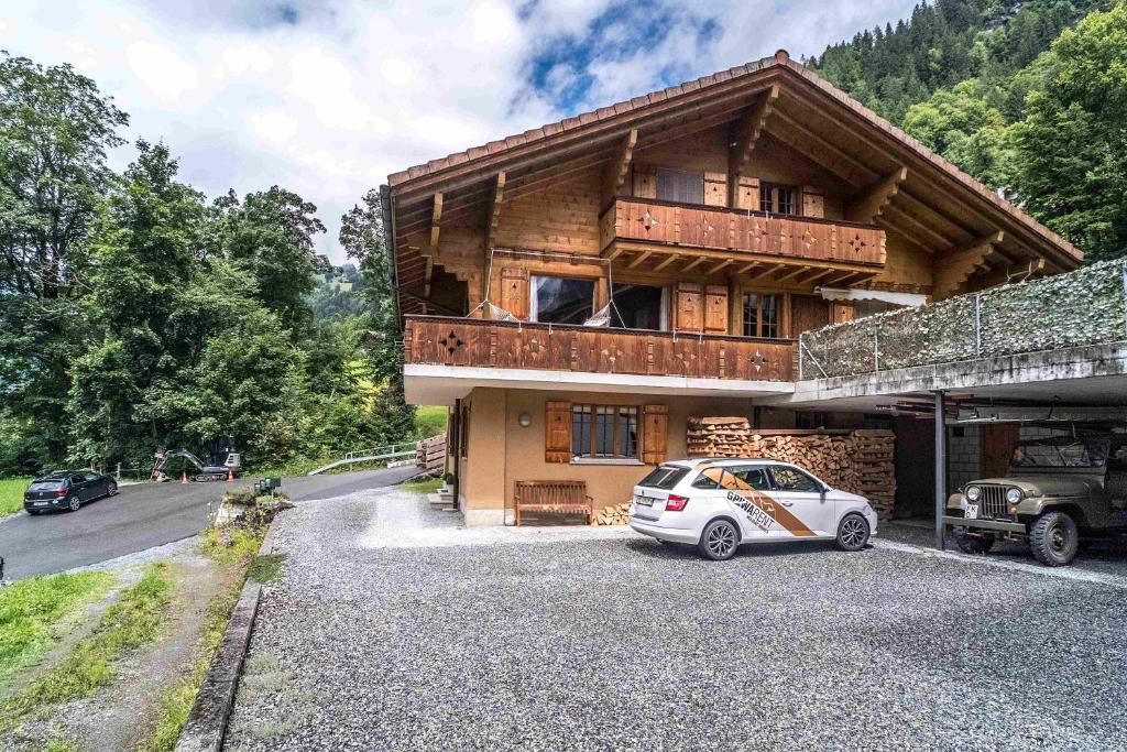 a house with a car parked in front of it at Apartment Rybibach Retreat in Lauterbrunnen