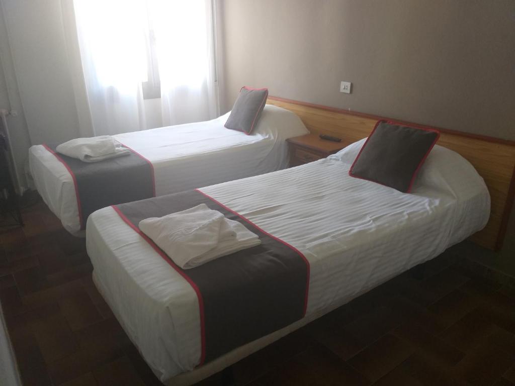 A bed or beds in a room at Hostal Alberana