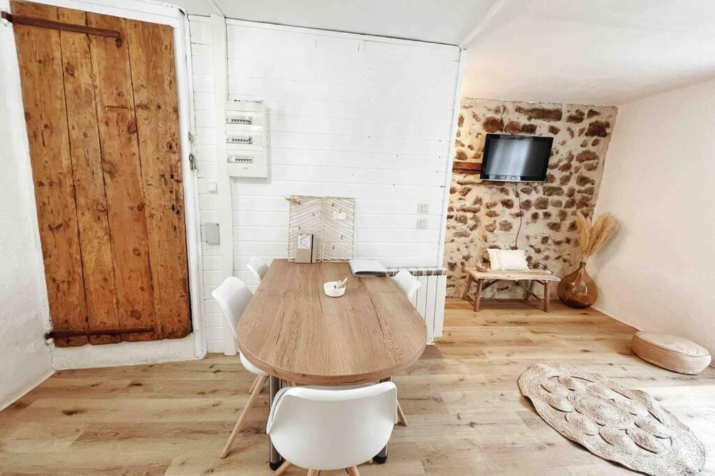 - une table et des chaises en bois dans une chambre avec porte dans l'établissement Gîte Chez Gabrielle, au Puy-en-Velay