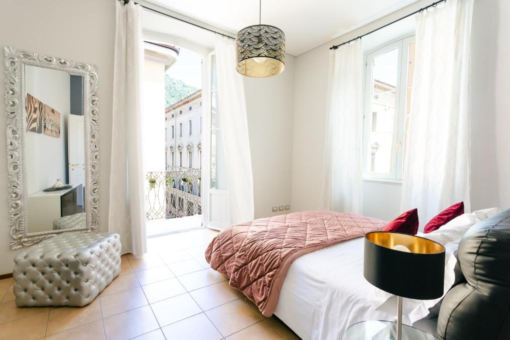 1 dormitorio con cama, espejo y silla en Relais Di Giada, en Como