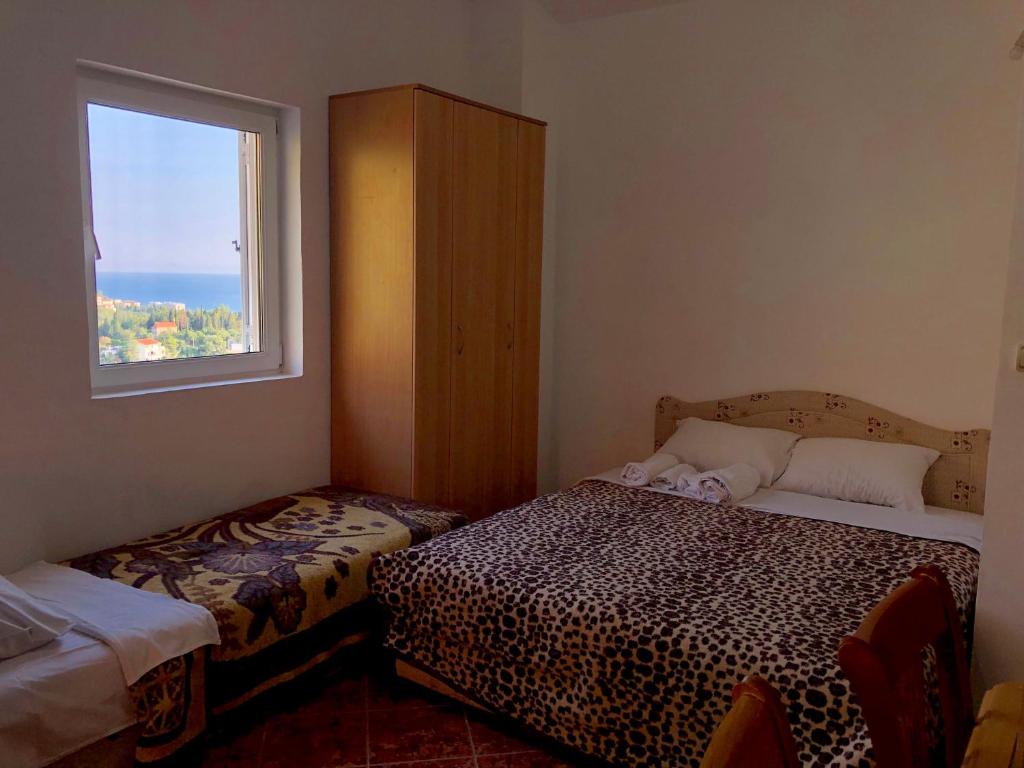 mały pokój z 2 łóżkami i oknem w obiekcie Kuća Radović w Budvie