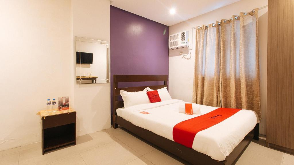 a bedroom with a bed and a purple wall at RedDoorz Plus at Manila Shandong Hotel in Manila