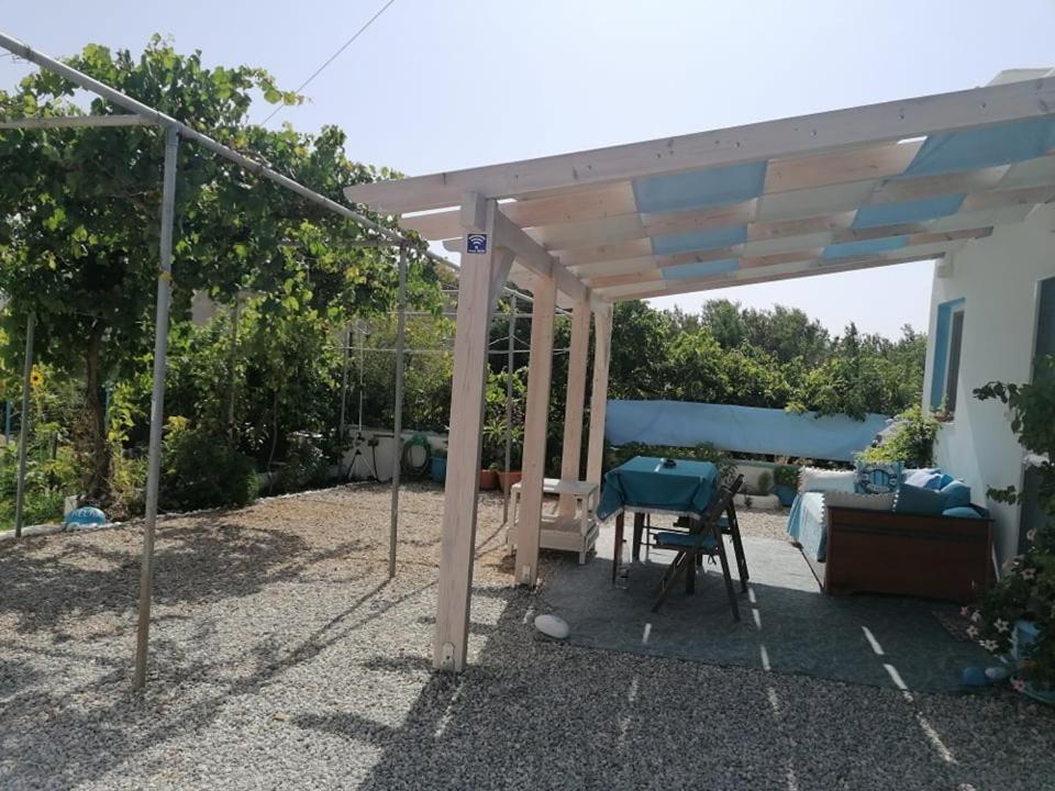 a wooden pergola with a couch and a table at Casa D'armaros in Kissamos