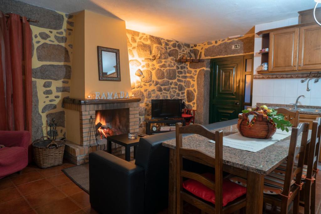 a kitchen with a table and a fireplace in a room at Casa da Ramada in Campo do Gerês