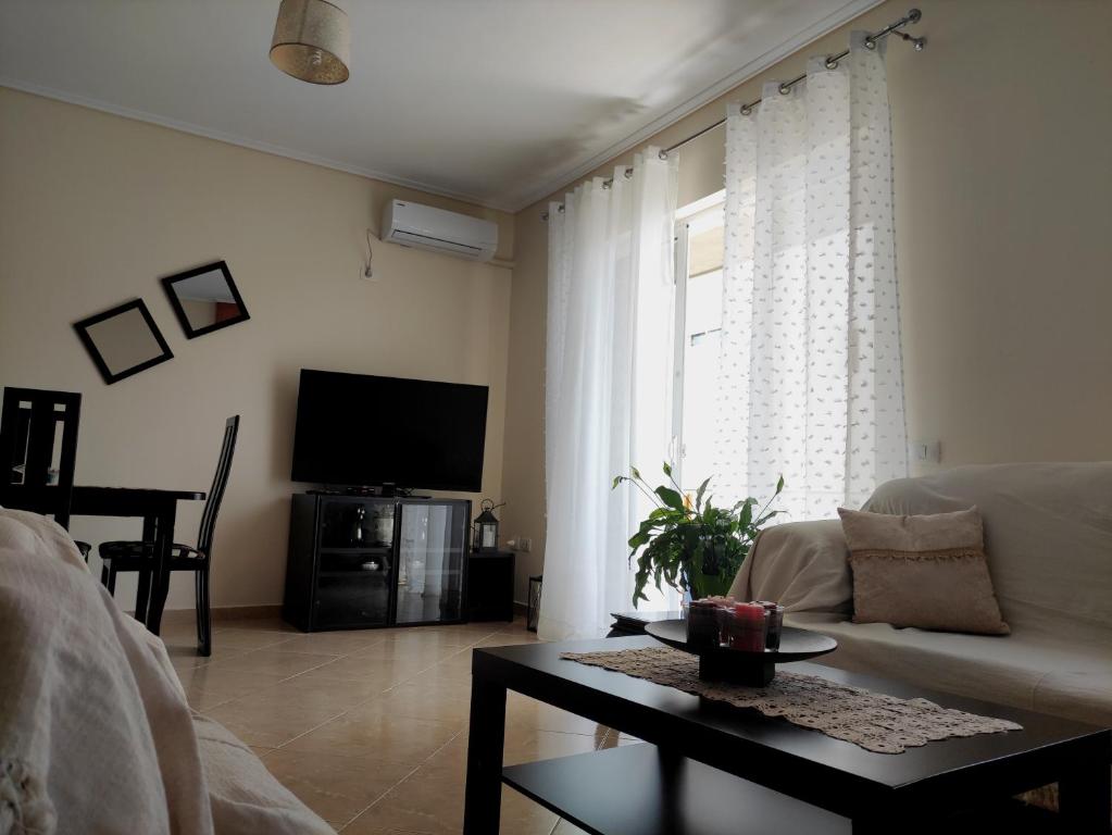 uma sala de estar com um sofá e uma televisão em Apartment Angel em Saranda