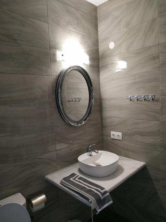 łazienka z umywalką i lustrem w obiekcie Ekaterini Apartments w Gouvii