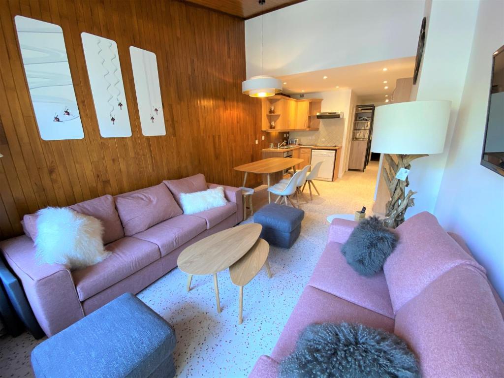 a living room with a pink couch and a table at Tignes duplex 8-10 p avec parking in Tignes