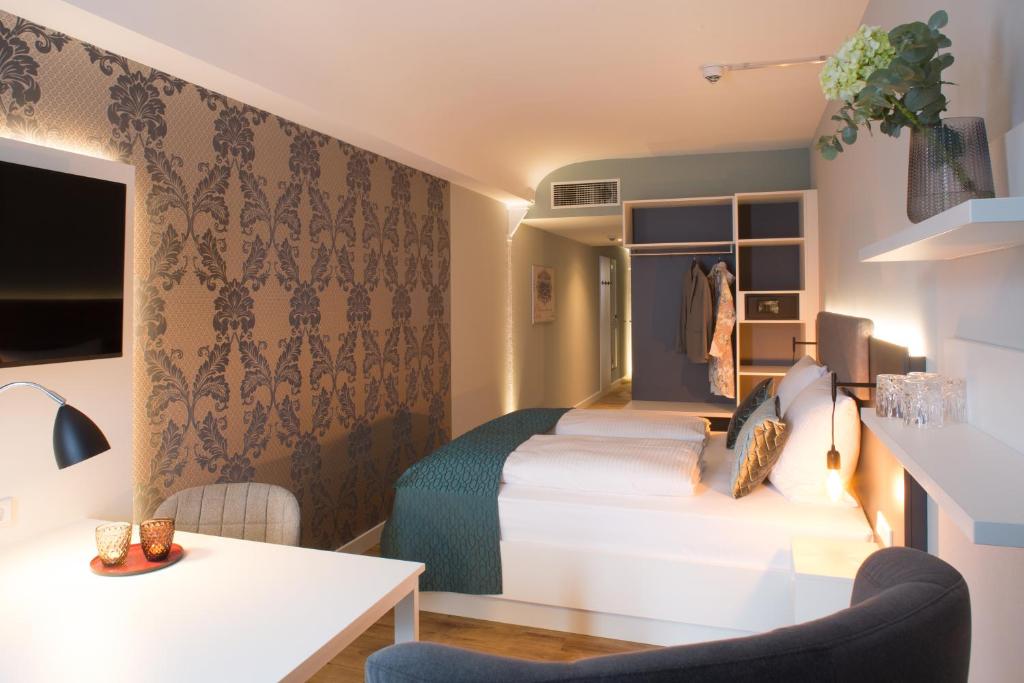 a hotel room with two beds and a table at Weberei Bendix Hotel & Appartements in Dülmen