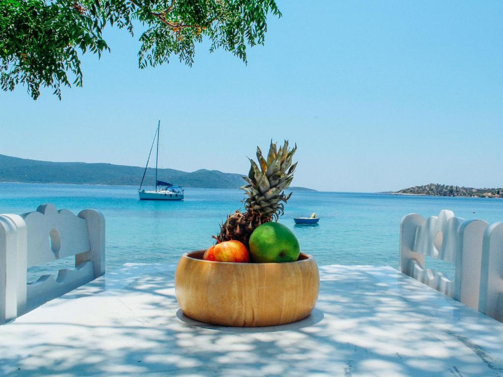 a bowl of fruit on a table next to the water at Klima Paradise in Klíma