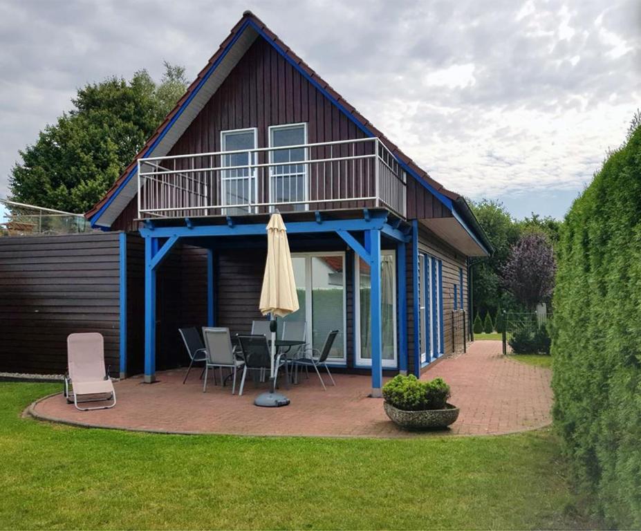 een huis met een terras en een patio met stoelen en een parasol bij Haus Gestrandet in Kaltenhof