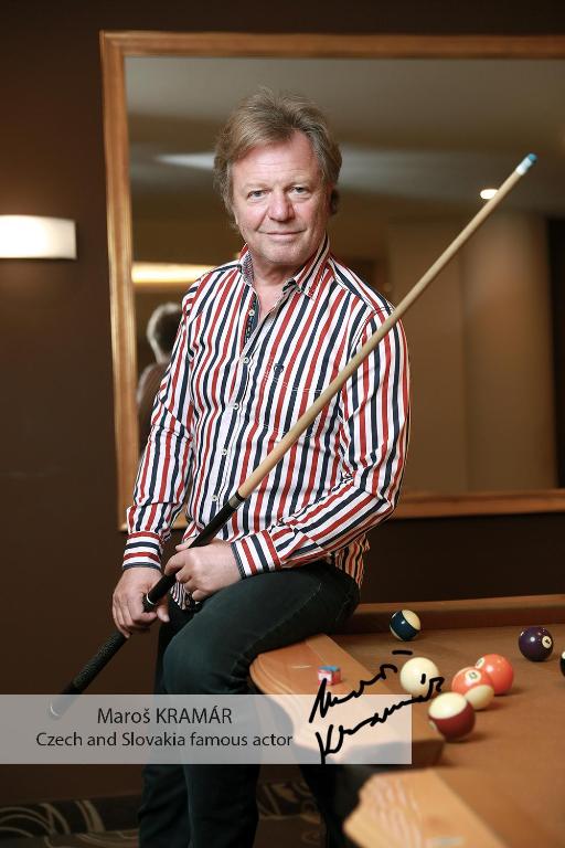 a man sitting on a pool table holding a cue at Don Giovanni Hotel Prague - Great Hotels of The World in Prague