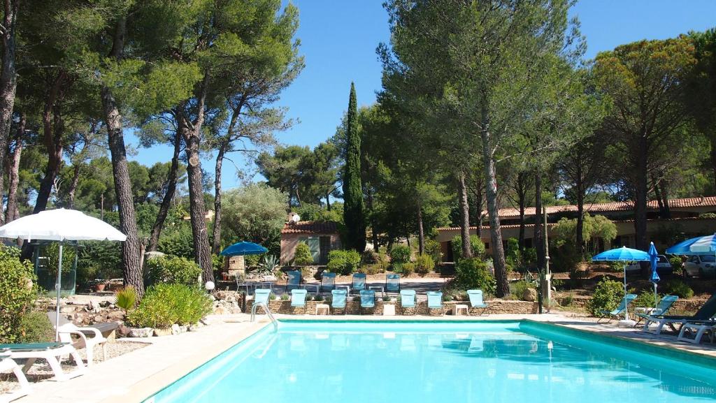 a swimming pool with chairs and umbrellas at La Cigalière in Le Beausset