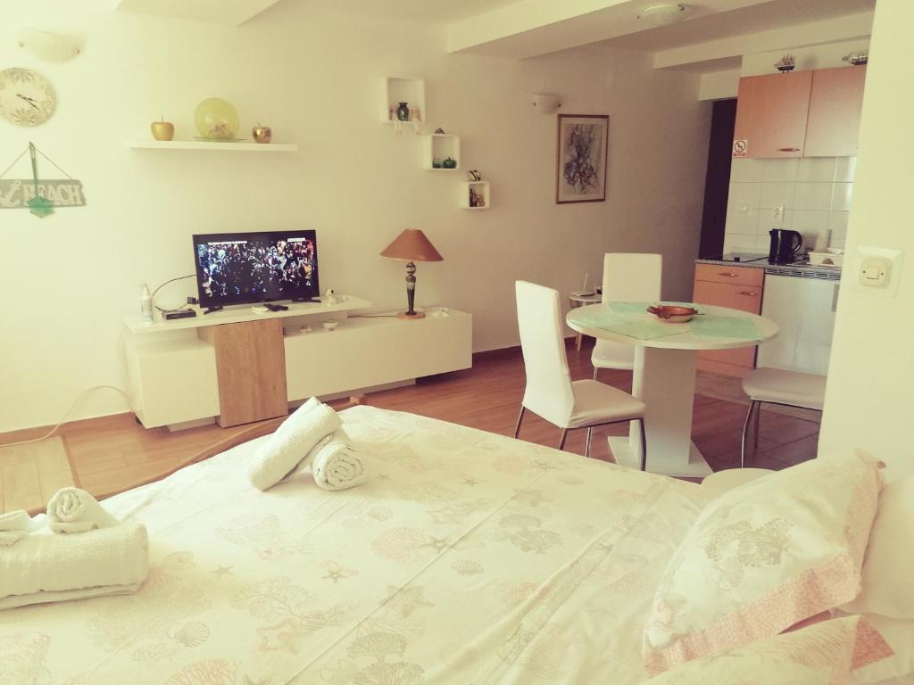 Cette chambre comprend un lit, une table et une cuisine. dans l'établissement Apartment Lju on the Beach, à Split