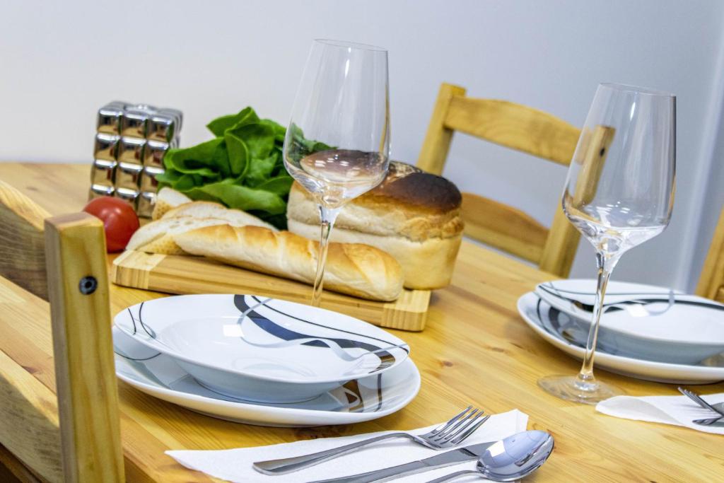 una mesa con platos y copas de vino. en CADeS accommodation, en Wolverhampton