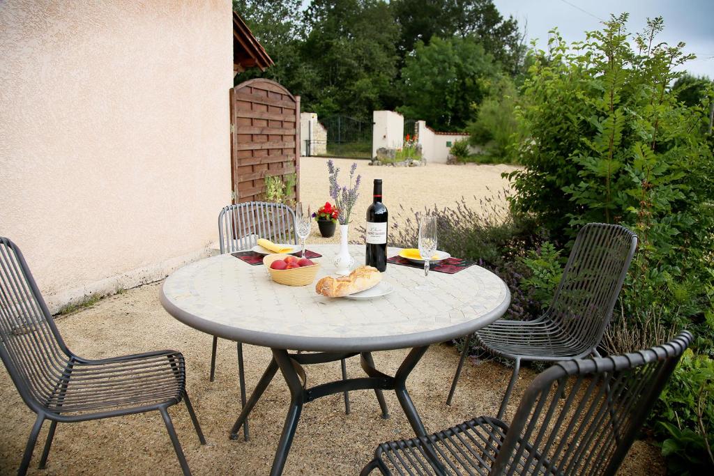 a table with a bottle of wine and a bowl of fruit at Launie Lea in Eyzerac