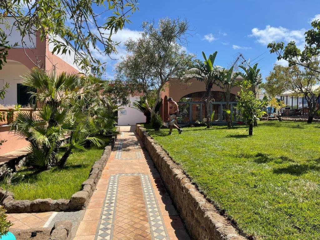 a garden with a brick path in front of a building at Hotel Lo Smeraldo in Ventotene