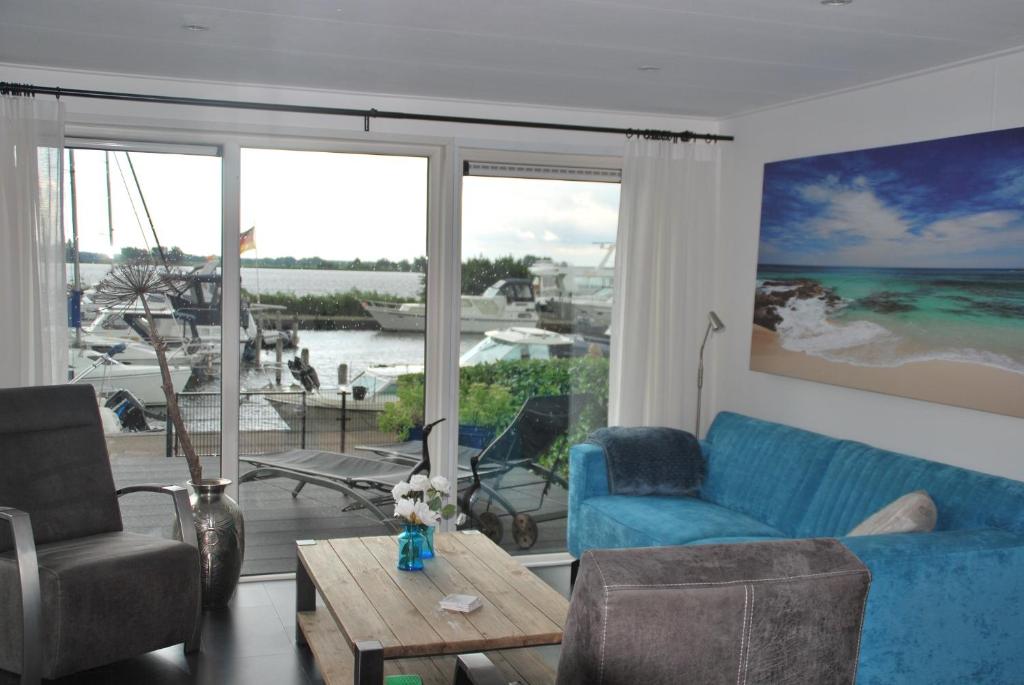 een woonkamer met een blauwe bank en een tafel bij Chalet Veluwemeerzicht Elburg in Biddinghuizen