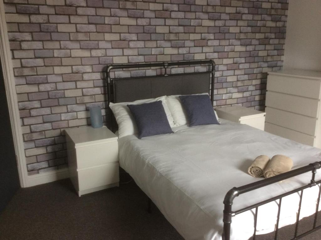 una camera con letto e muro di mattoni di 204 Uttoxeter Old Road a Derby