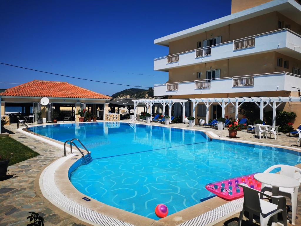 a large swimming pool in front of a hotel at Nafsika Hotel in Agios Stefanos