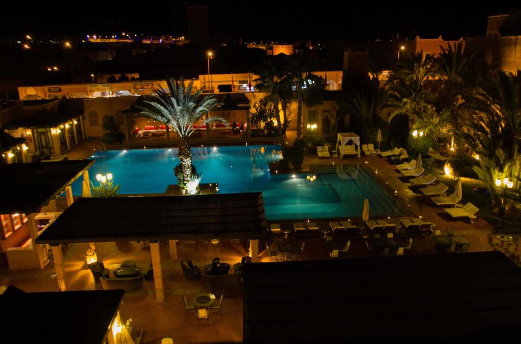 a view of a swimming pool at night at Berbère Palace in Ouarzazate