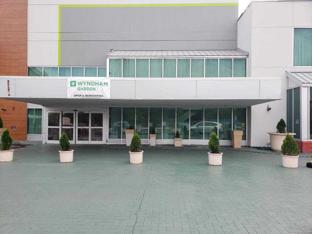 a building with potted plants in front of it at Wyndham Garden Totowa in Totowa