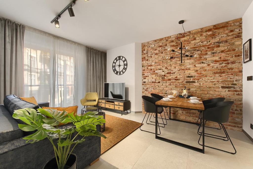 uma sala de estar com uma parede de tijolos em Elite Apartament IMPERO z Parkingiem em Poznań
