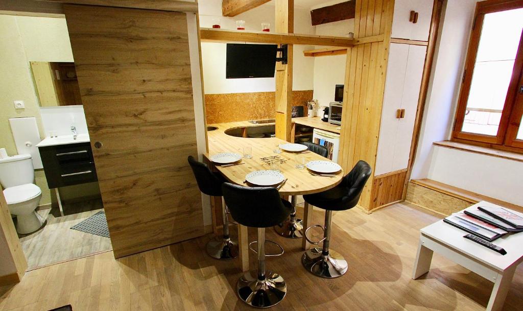 a kitchen with a table and chairs in a room at Charmant Studio Cité Vauban in Briançon