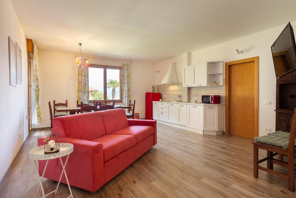 een woonkamer met een rode bank en een keuken bij Appartamento Albert - Stresa in Stresa