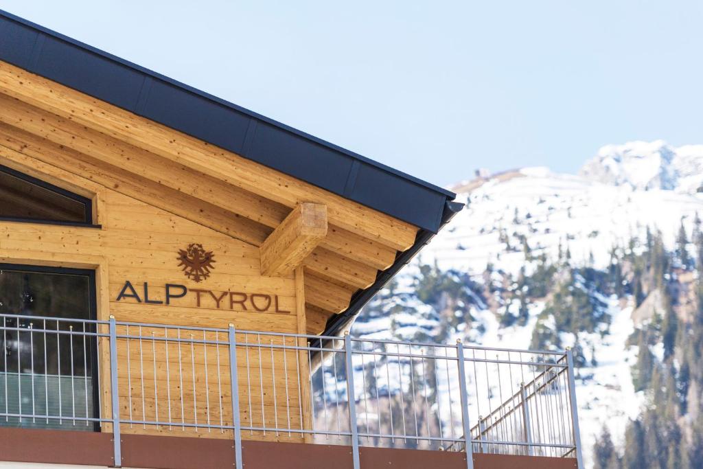 a sign on the side of a building with snow at Quality Hosts Arlberg - ALPtyrol Appartements in Sankt Anton am Arlberg