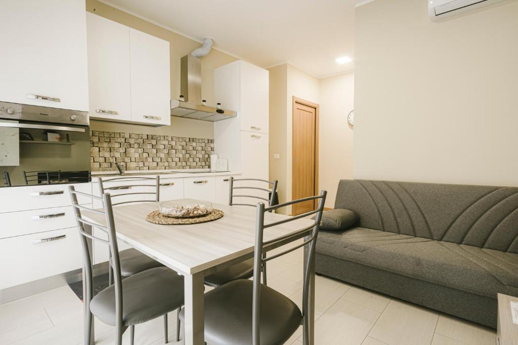 a kitchen and living room with a table and chairs at Grab a Flat in Coroneo in Trieste