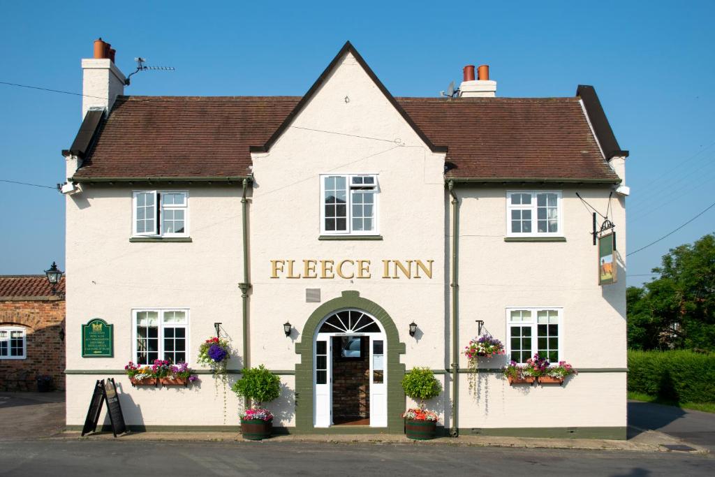a large white building with the entrance to the fleece inn at The Fleece Inn in Bishop Wilton