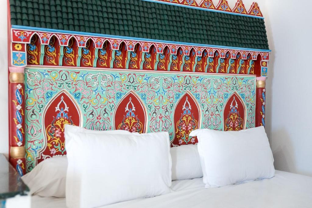 - un lit avec deux oreillers devant un mur dans l'établissement Hotel Moroccan House Casablanca, à Casablanca