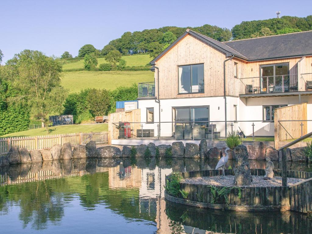 a house next to a river with a building at Defoes View in Honiton