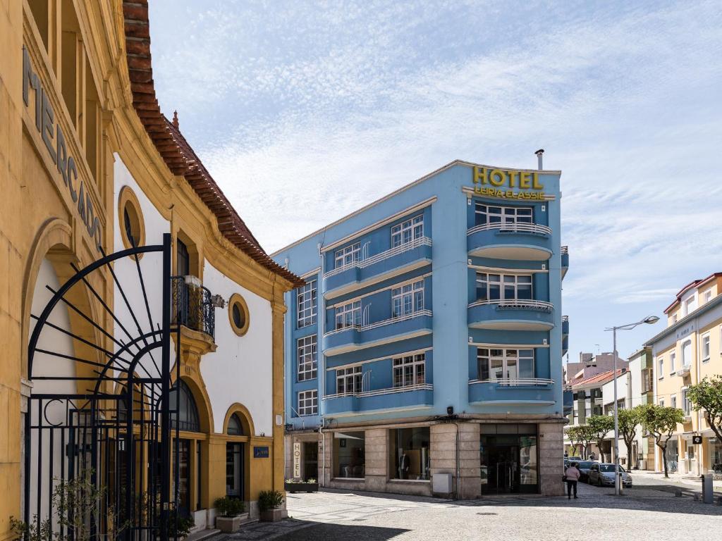 a blue hotel on a street with buildings at Hotel Leiria Classic in Leiria