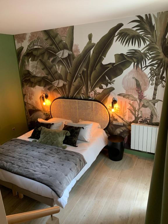 a bedroom with a large bed with a plant mural at Les Cotonnades Lorient in Lorient